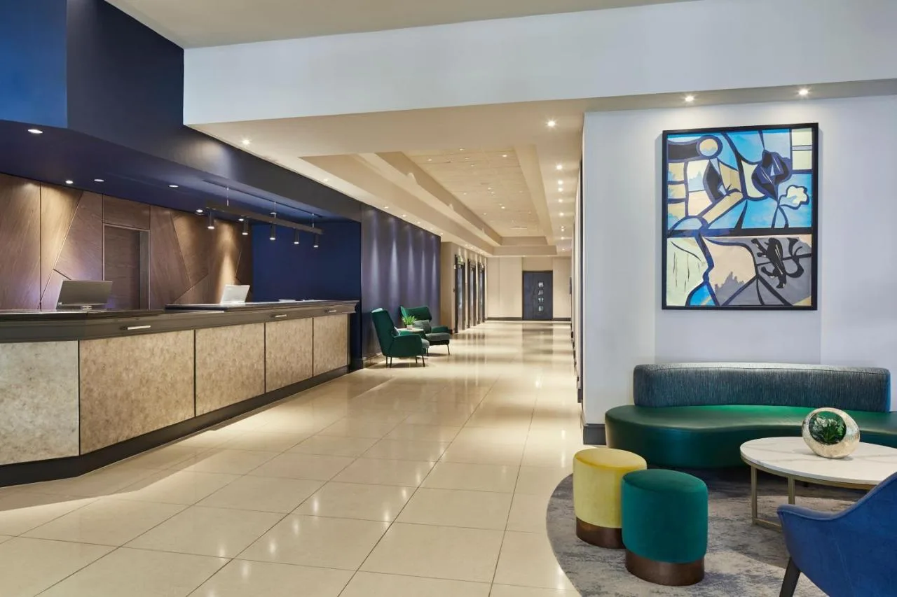 A lobby with a waiting area with green chairs at Cardiff Marriott Hotel in Cardiff