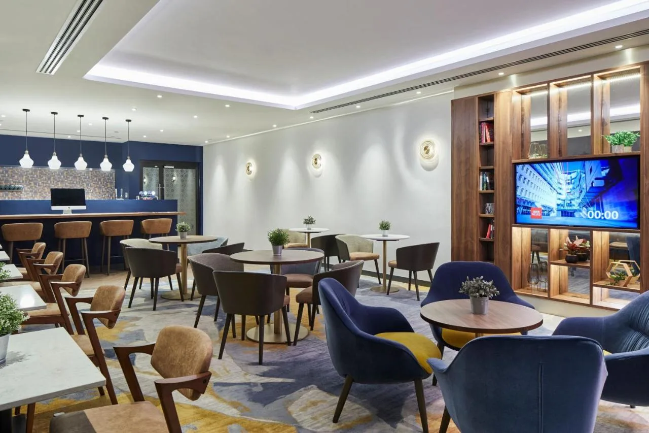 A restaurant with tables and chairs and a TV at Cardiff Marriott Hotel in Cardiff