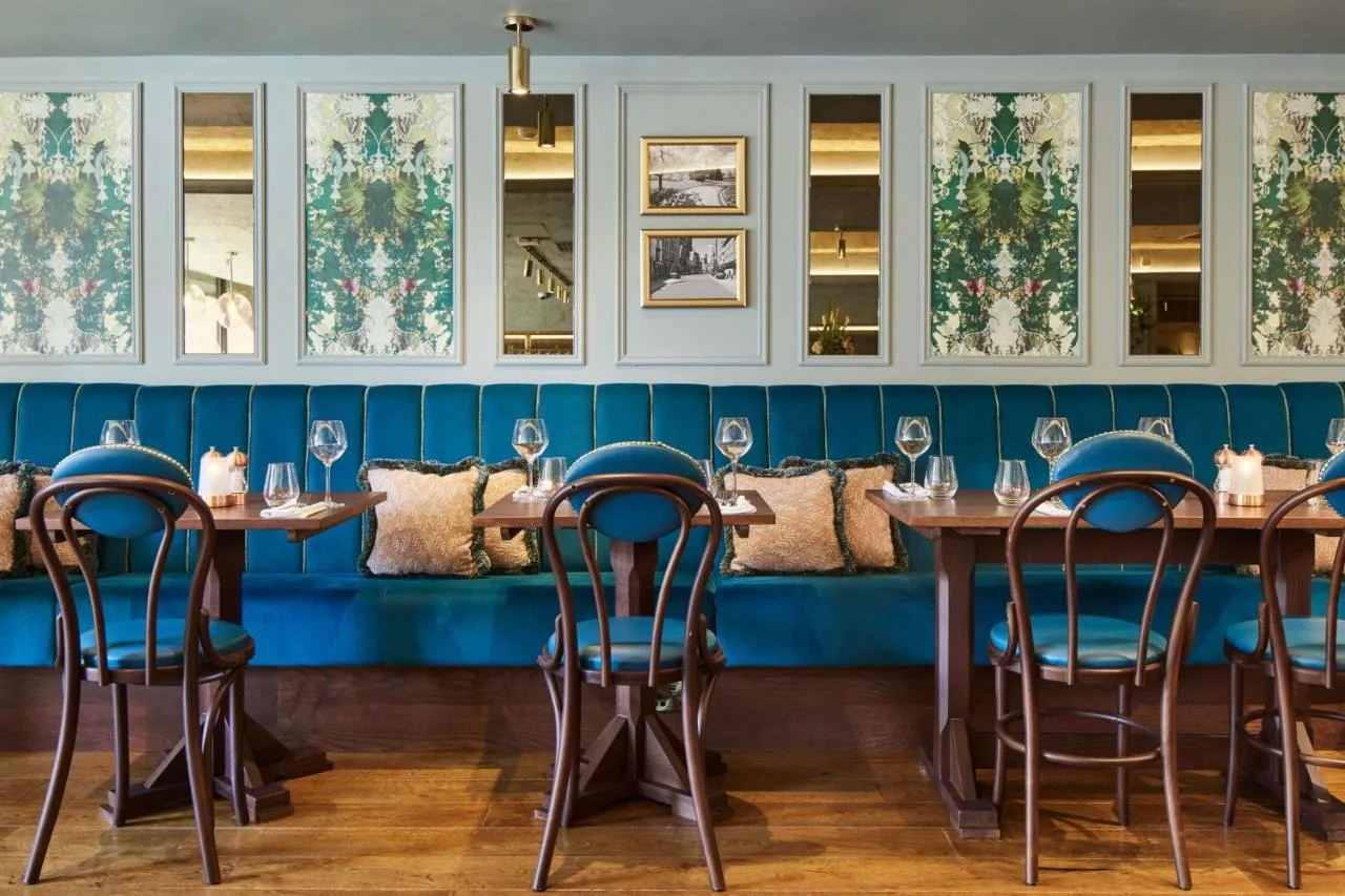 A row of tables in a restaurant with blue walls at Cardiff Marriott Hotel in Cardiff