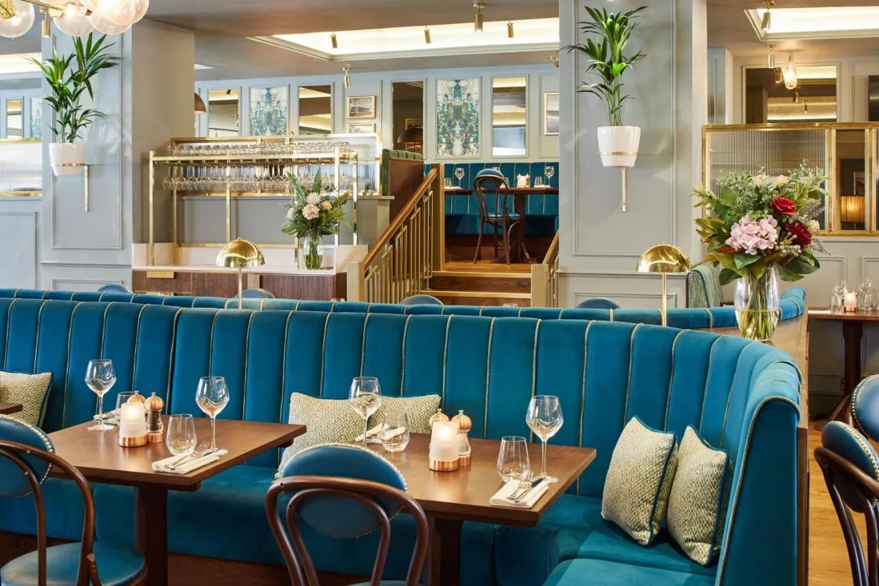 A blue couch in a restaurant with tables and chairs at Cardiff Marriott Hotel in Cardiff